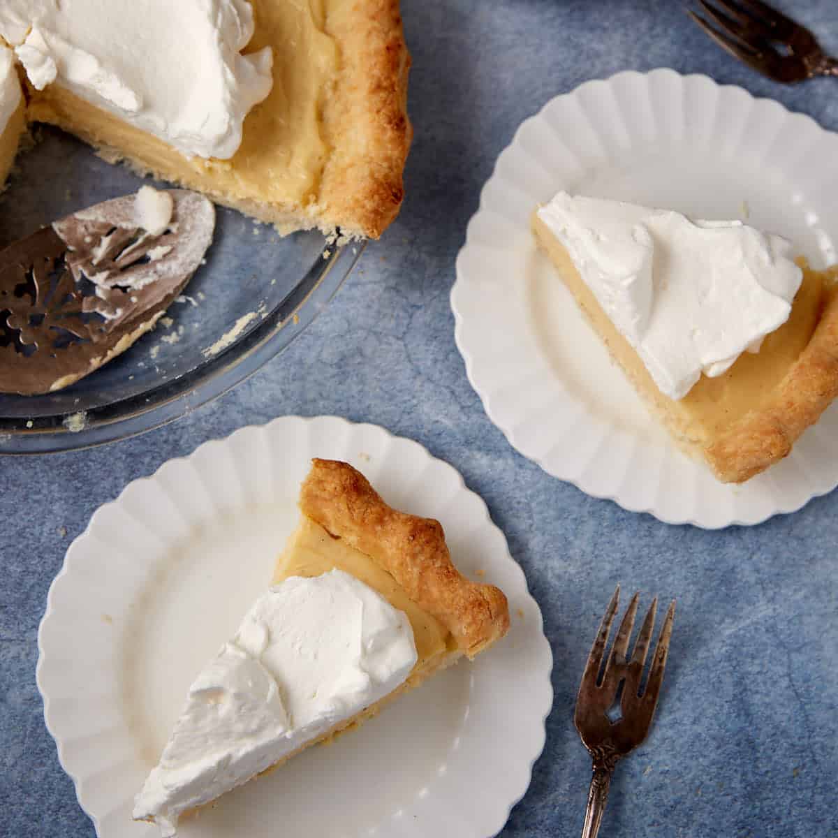 slices of vanilla pudding pie on white plates.
