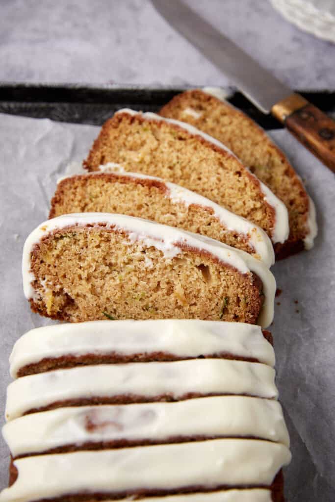pineapple zucchini bread sliced with a knife in the background. 