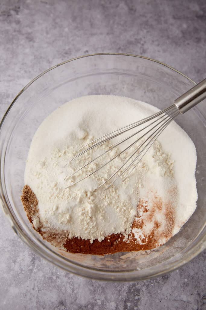 pineapple zucchini bread dry ingredients in glass mixing bowl with whisk. 