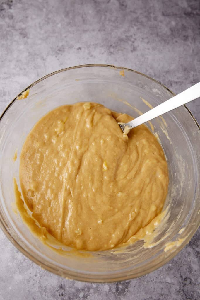 batter resting in a glass bowl with a metal mixing spoon. 
