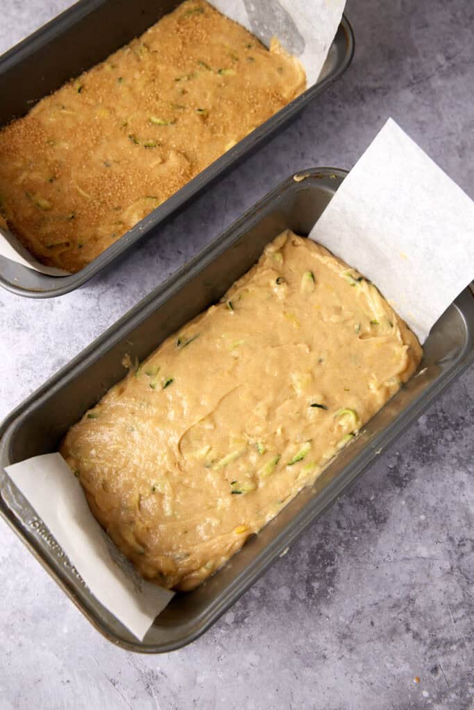 pineapple zucchini bread batter in loaf pans lined with parchment paper.