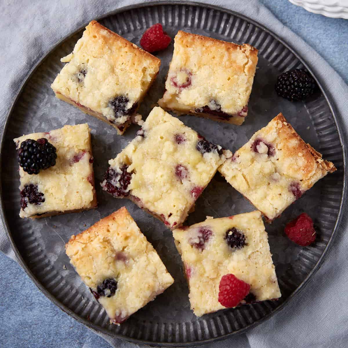 sliced fruit crumble bars on a black plate.
