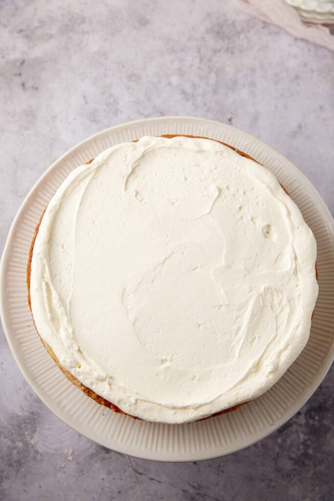 frosting spread on top of the confetti cake.