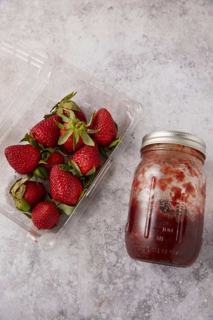 strawberries and strawberry jam on a gray background.