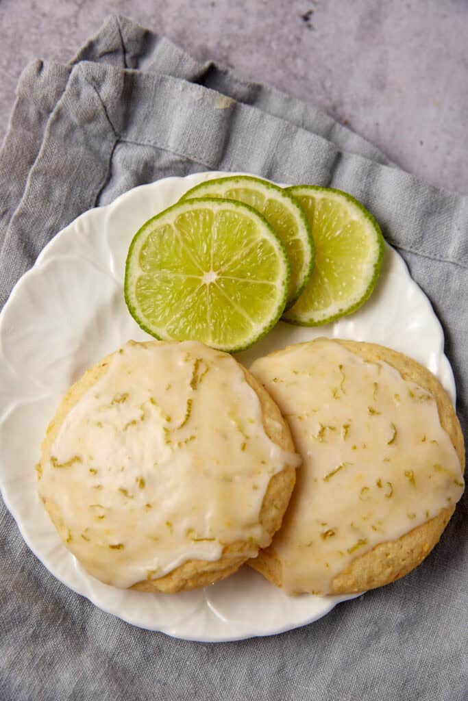 lime cookies on a white plate with lime slices on the side. 