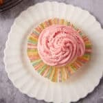 Raspberry cupcake on a white plate.