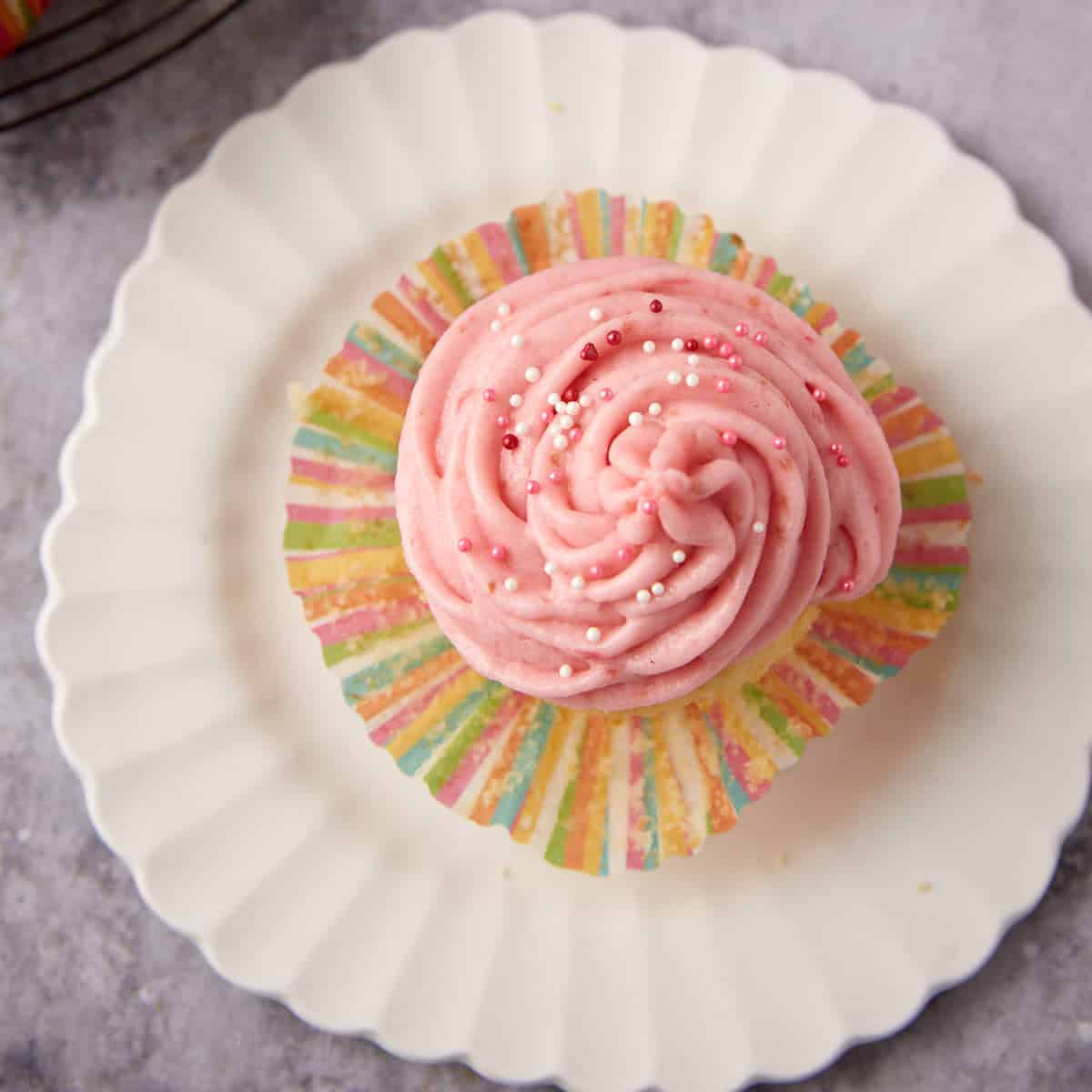 Raspberry cupcake on a white plate.