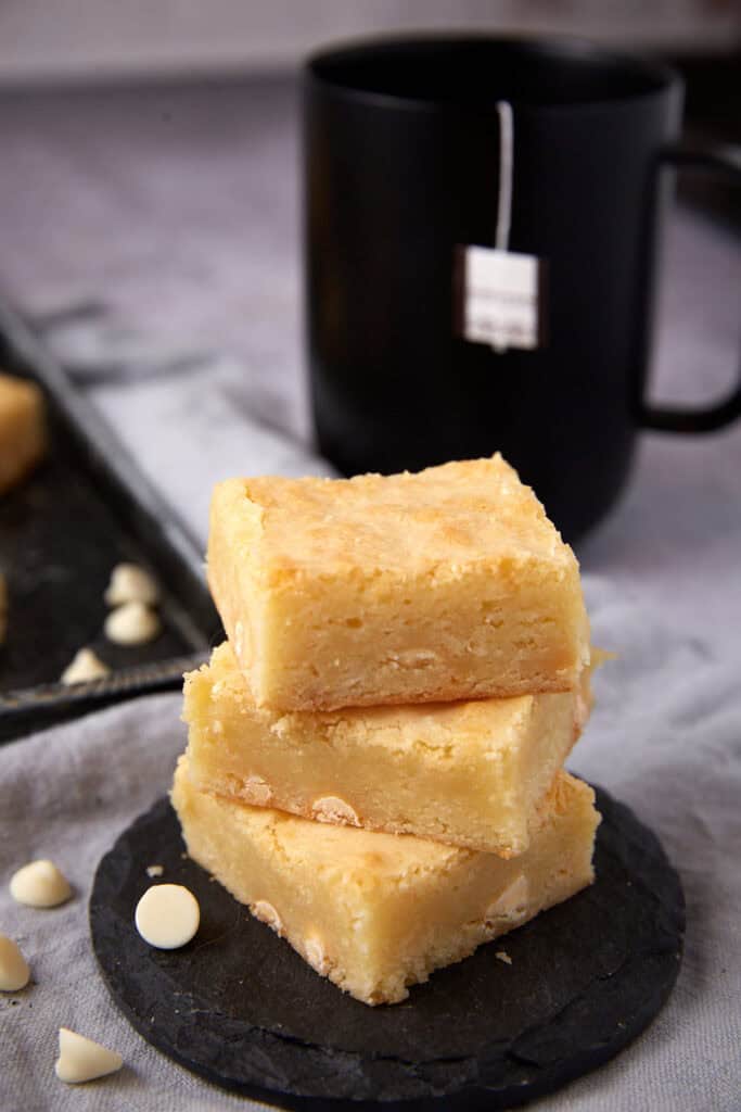 white chocolate brownies on a black plate.