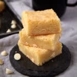 white chocolate brownies on a black plate.