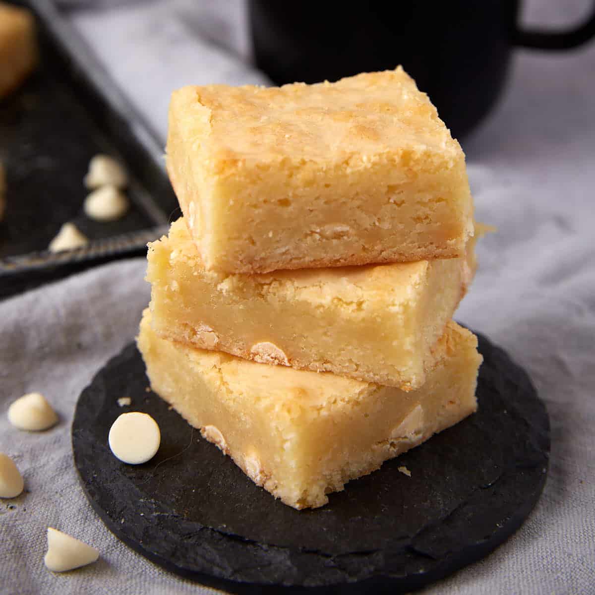 white chocolate brownies on a black plate.