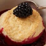 A bowl of blackberry cobbler with a biscuit on top.