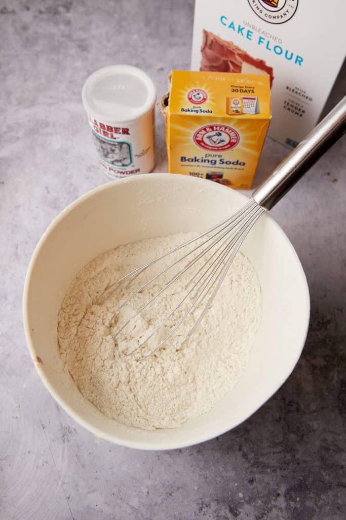 strawberry cake dry ingredients in a white bowl with a whisk.