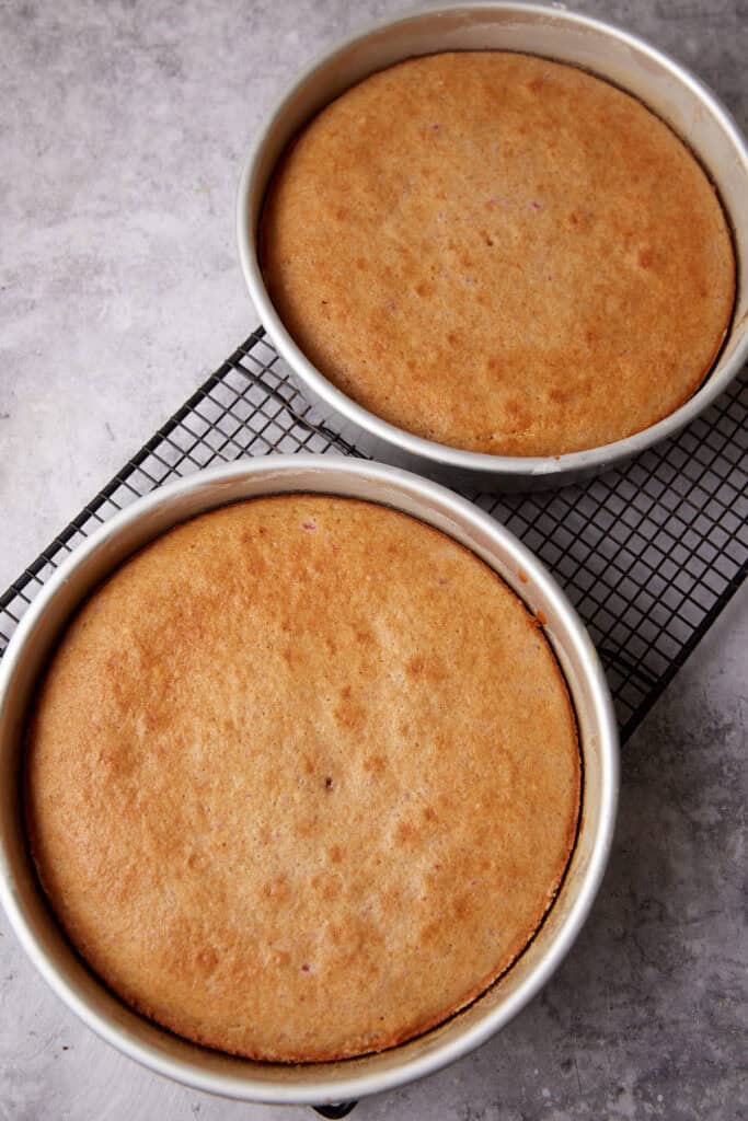 strawberry cake layers baked in cake pans.