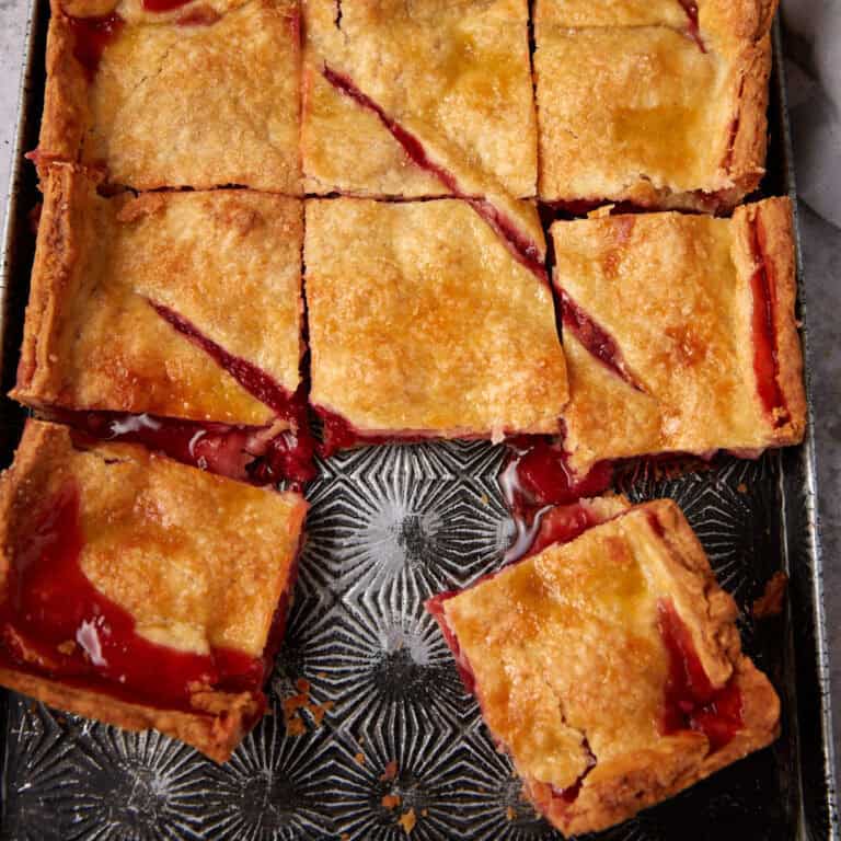 A square strawberry slab pie with a slice missing.
