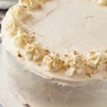 A cream cheese frosted sweet potato cake on a cake platter.