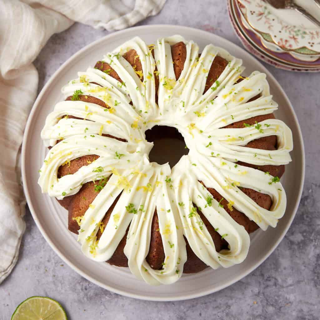 A bundt cake with white frosting and a slice taken out.