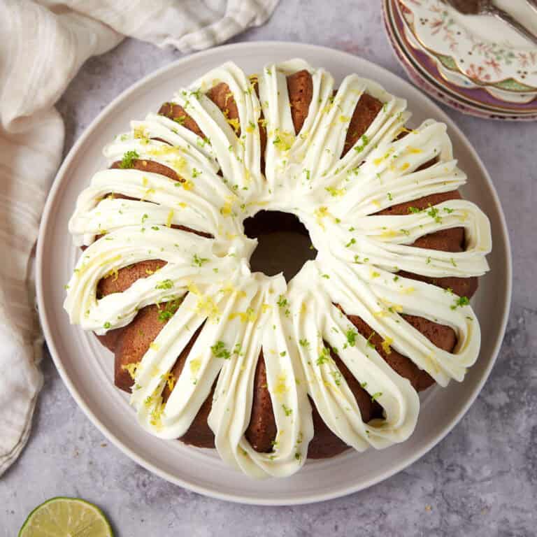 A bundt cake with white frosting and a slice taken out.