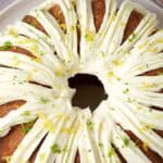 A bundt cake with white frosting and a slice taken out.