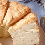 Angel food cake on a cake stand cut into slices.