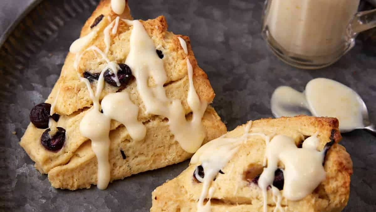 two blueberry scones drizzled with glaze.