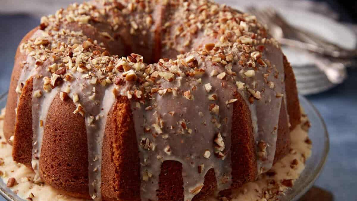 A butter pecan pound cake on a cake stand.