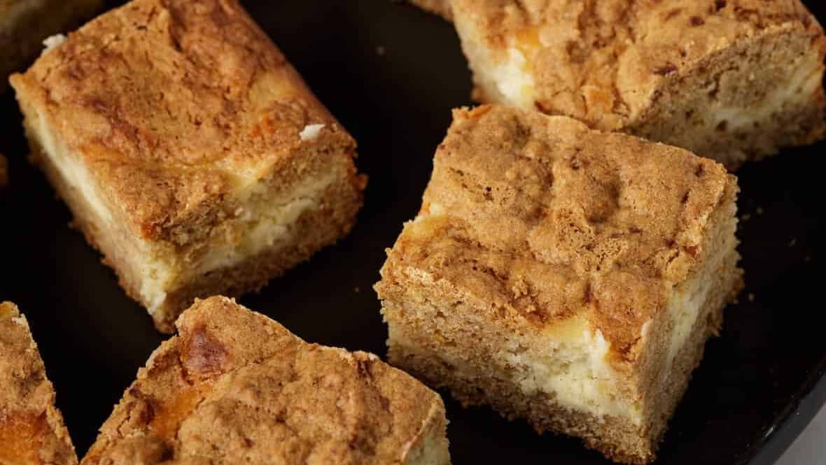 carrot cake cheesecake squares on a platter.