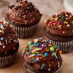 A cake stand with frosted chocolate cupcakes.
