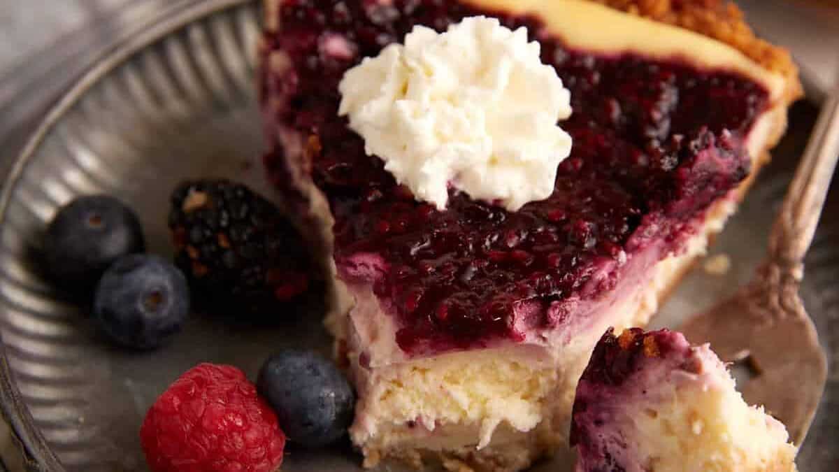 A slice of cream cheese pie with a bite on a fork.
