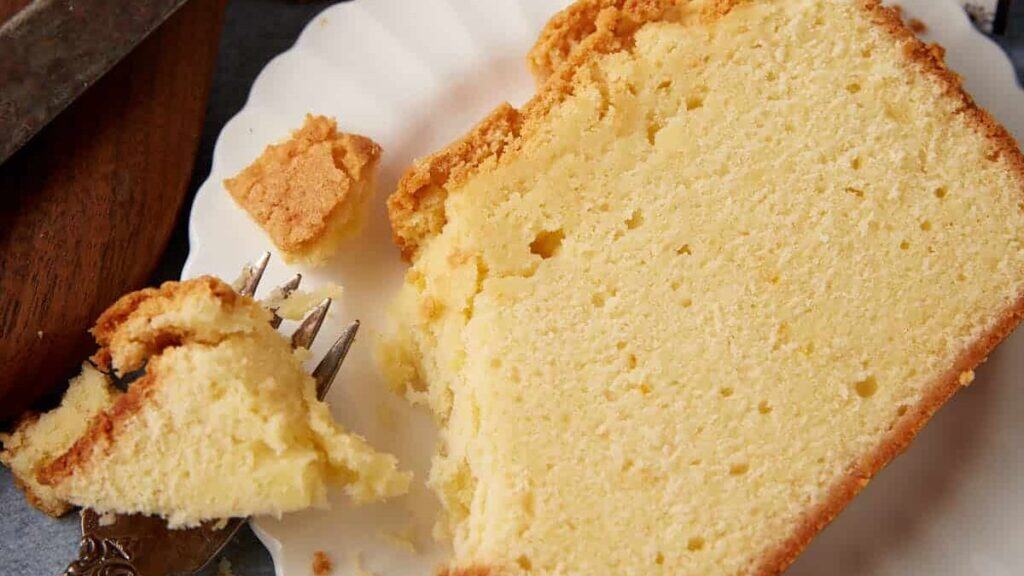 A slice of cream cheeses pound cake with a bite taken out.