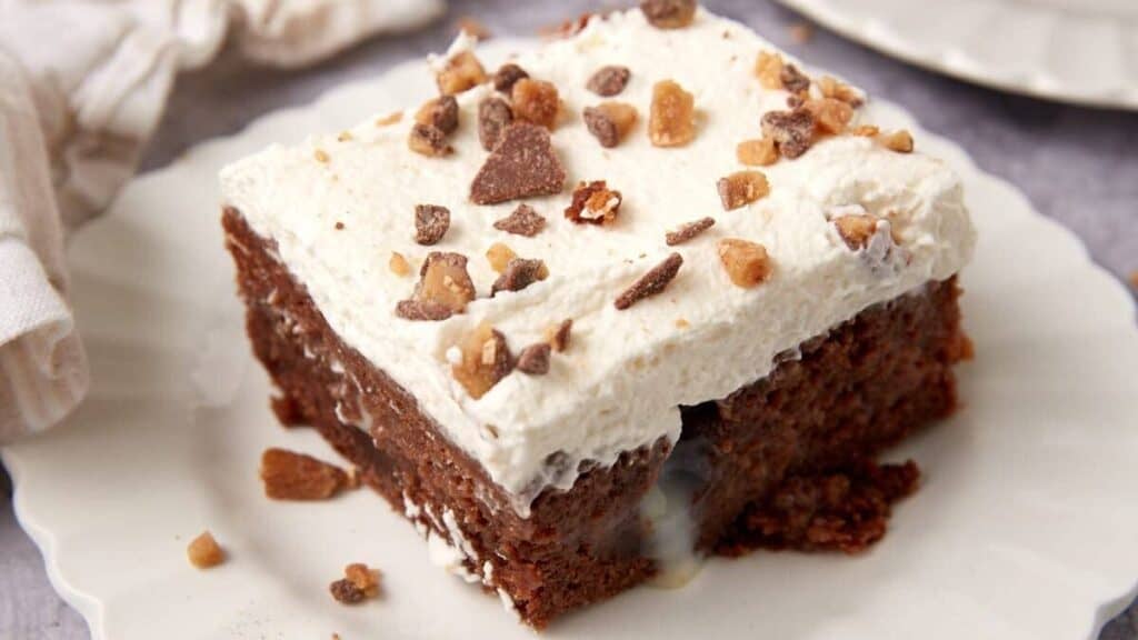 piece of heath bar cake on a white plate.