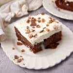 piece of heath bar cake on a white plate.