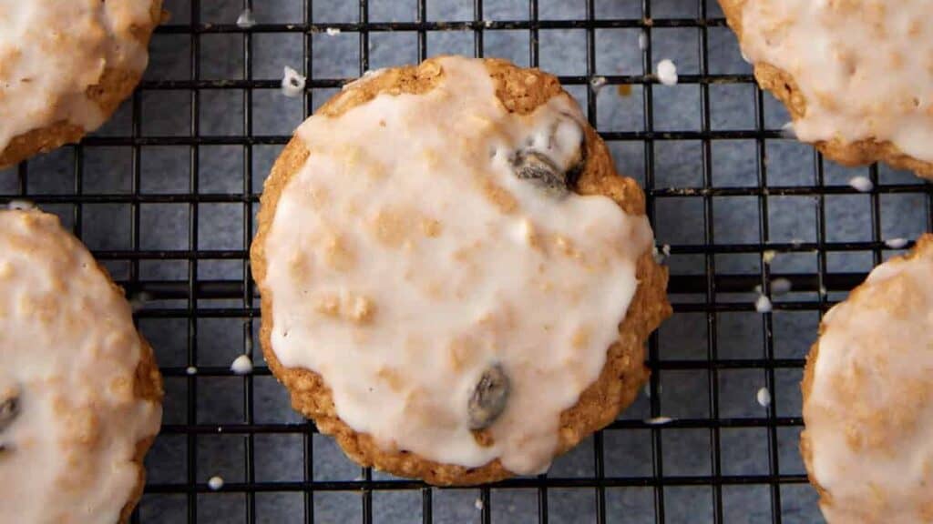 Iced oatmeal cookies on a wire rack.