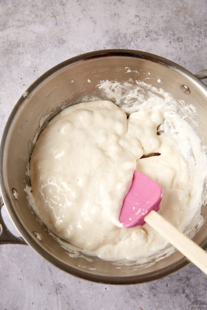 marshmallows melting in a saucepan with a spatula.