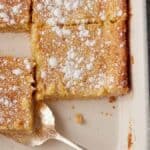 Paula Deen butter cake in a baking dish with a serving spoon.