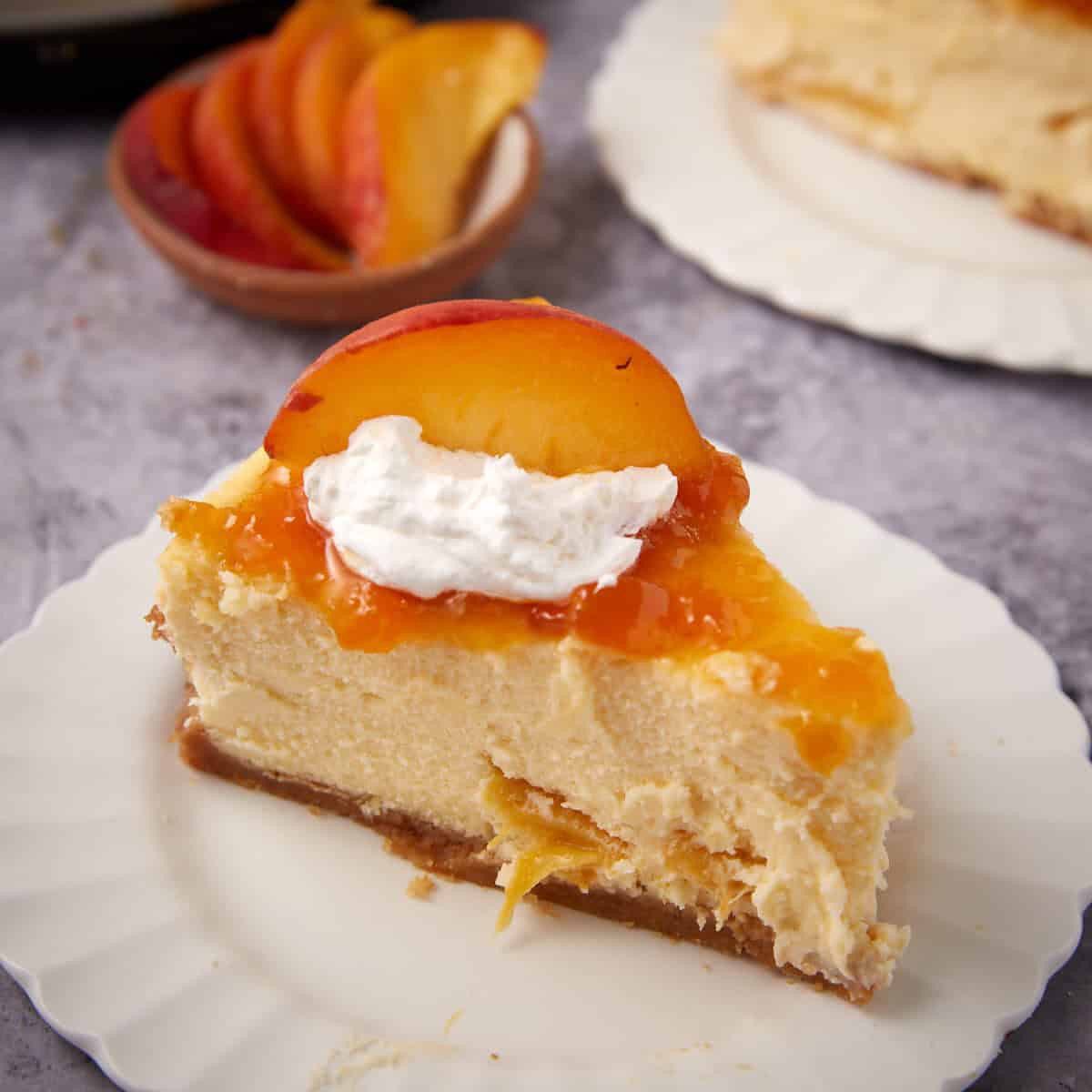 slice of peach cheesecake on a white plate.