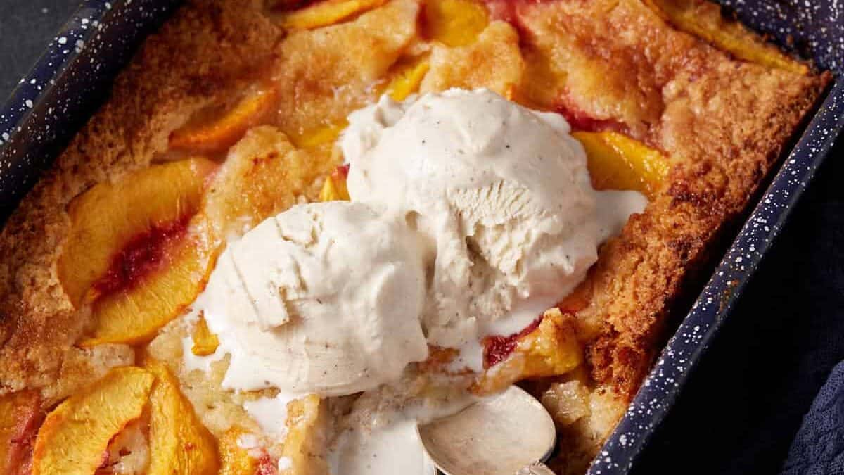 peach cobbler cake topped with ice cream.