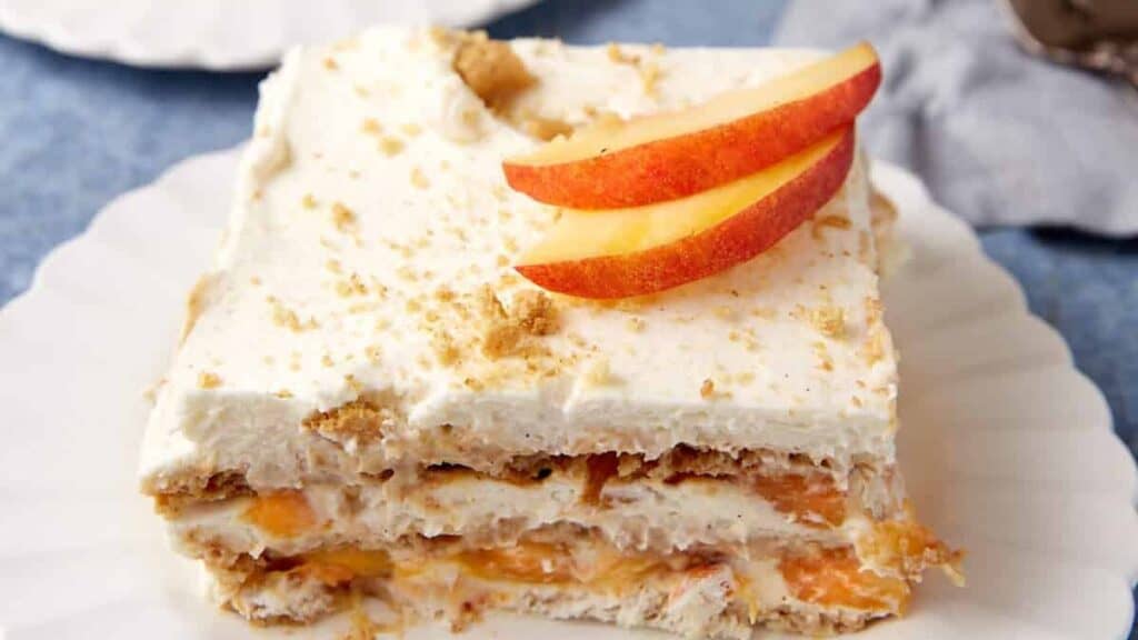 Two servings of peach icebox cake on white plates.