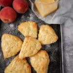 peach scones with peaches and peach glaze on the side.