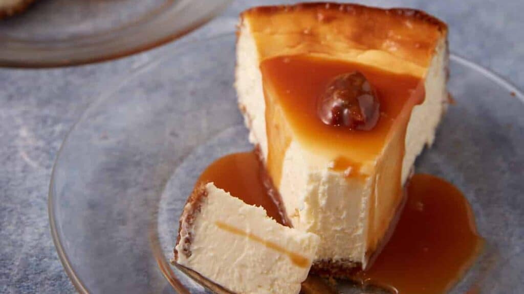 A slice of praline cheesecake with a bite taken out.
