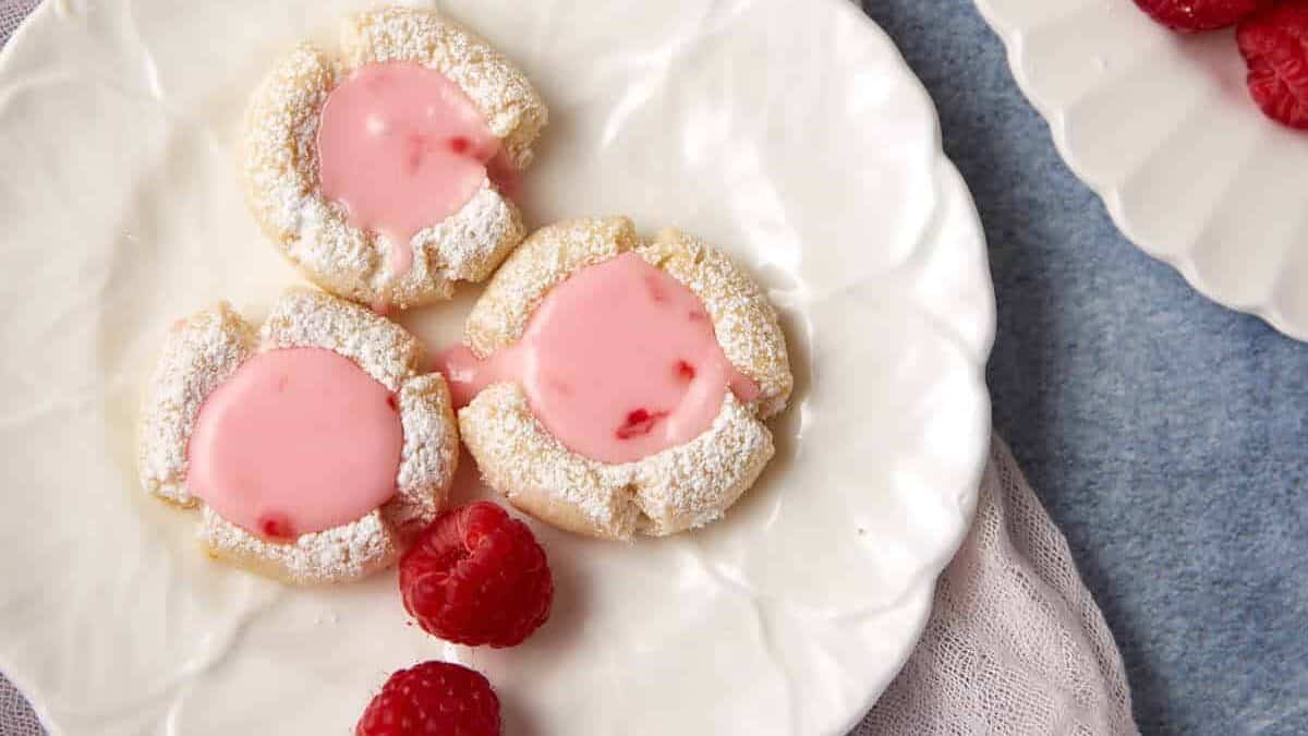 Three raspberry lemonade cookies on a plate.