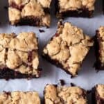 A batch of raspberry brownie bars on parchment paper.