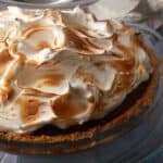 A s'mores pie under a cake dome.