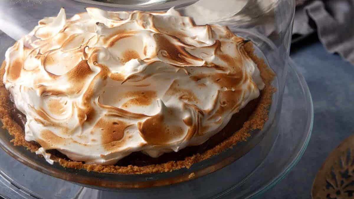 A s'mores pie under a cake dome.
