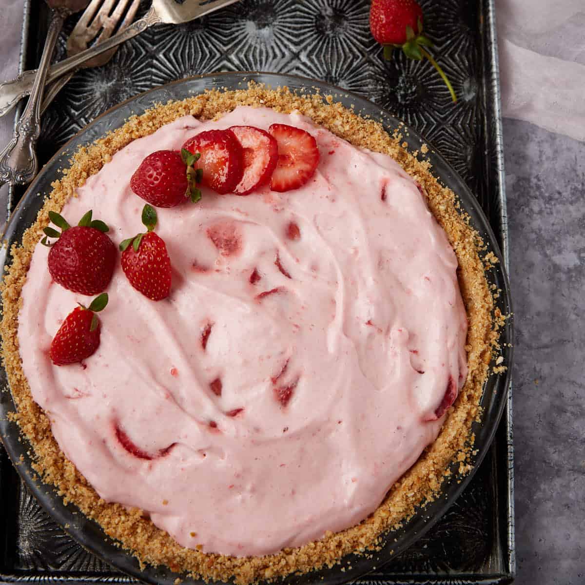 strawberry chiffon pie garnished with sliced and whole strawberries.