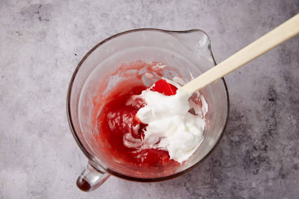 fluffy egg whites being mixed into the strawberry syrup. 