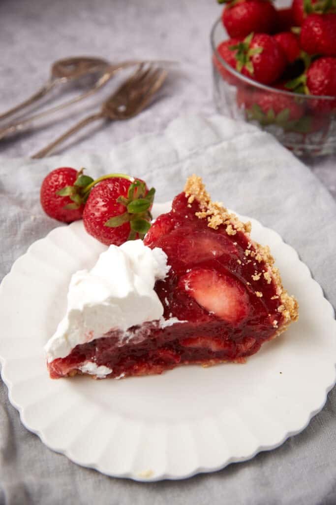 A slice of strawberry pie on a white plate.