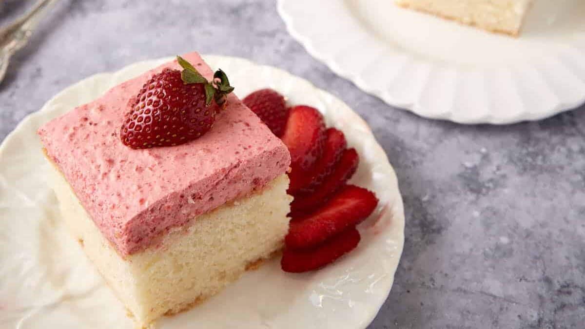 Slices of strawberry mousse cake on white plates.