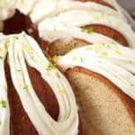 A bundt cake with white frosting and a slice cut out.