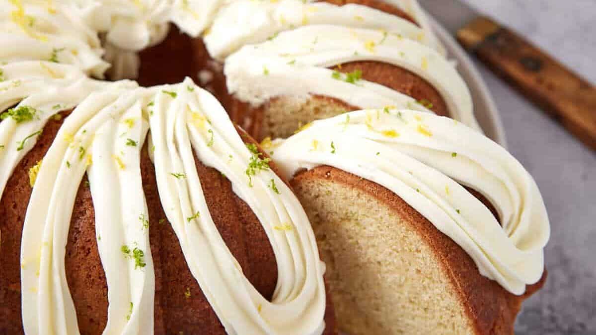 A bundt cake with white frosting and a slice cut out.