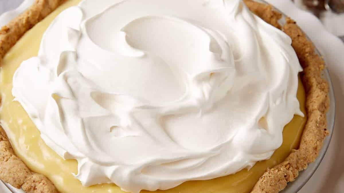 banana cream pie on a white cake stand.